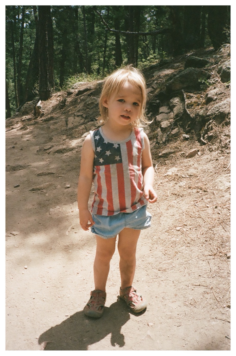 Lily on a sunny forest trail in a stars-and-stripes tank top